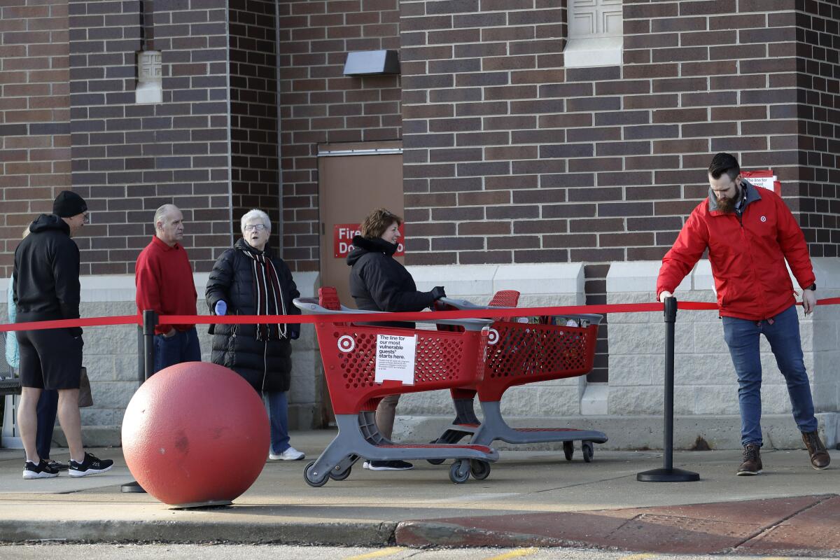 Grocery services are in high demand. Above, people wait to enter a Target store last month in Glenview, Ill.