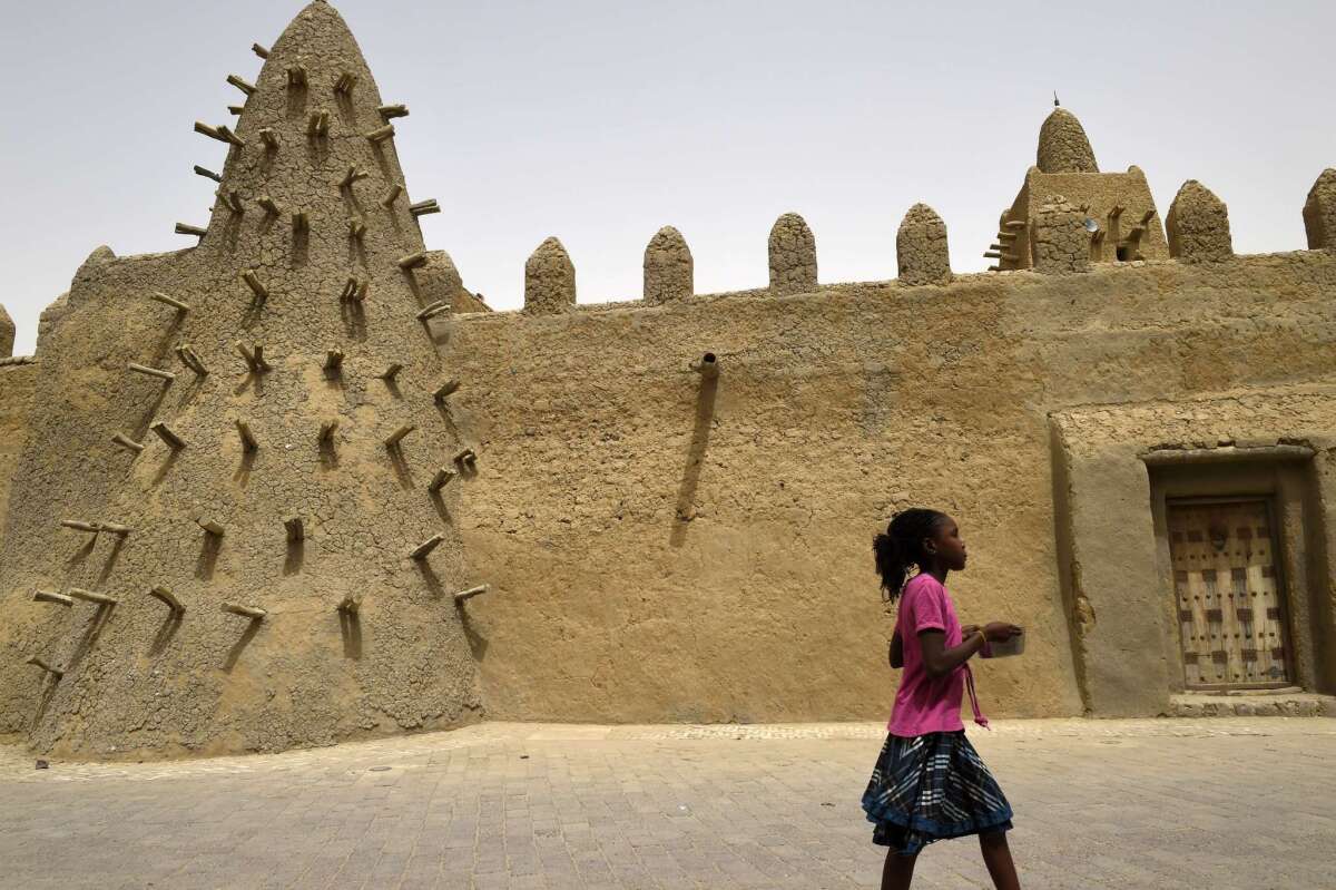Conservators have almost completed work on a restoration of Timbuktu's famous mud-brick architecture after it suffered damage in the hands of Islamic militants in 2012. A girl walks along the surrounding wall of the Djingareyber Mosque last month.