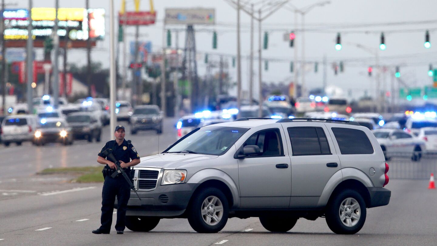 An East Baton Rouge police officer patrols Airline Highway after three officers were shot to death Sunday morning.