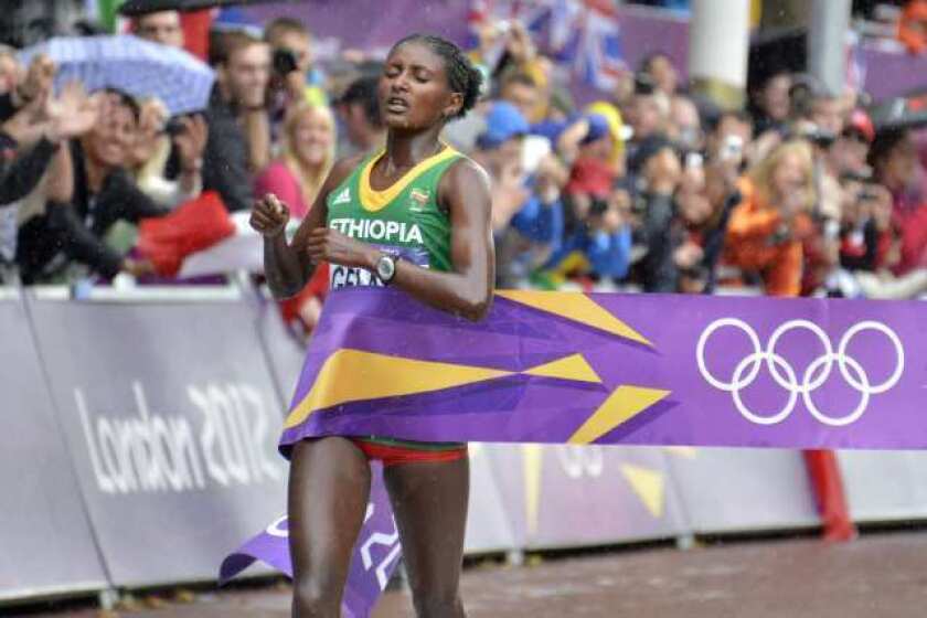 Ethiopia's Tiki Gelana crosses the finish line to win gold in the women's marathon.