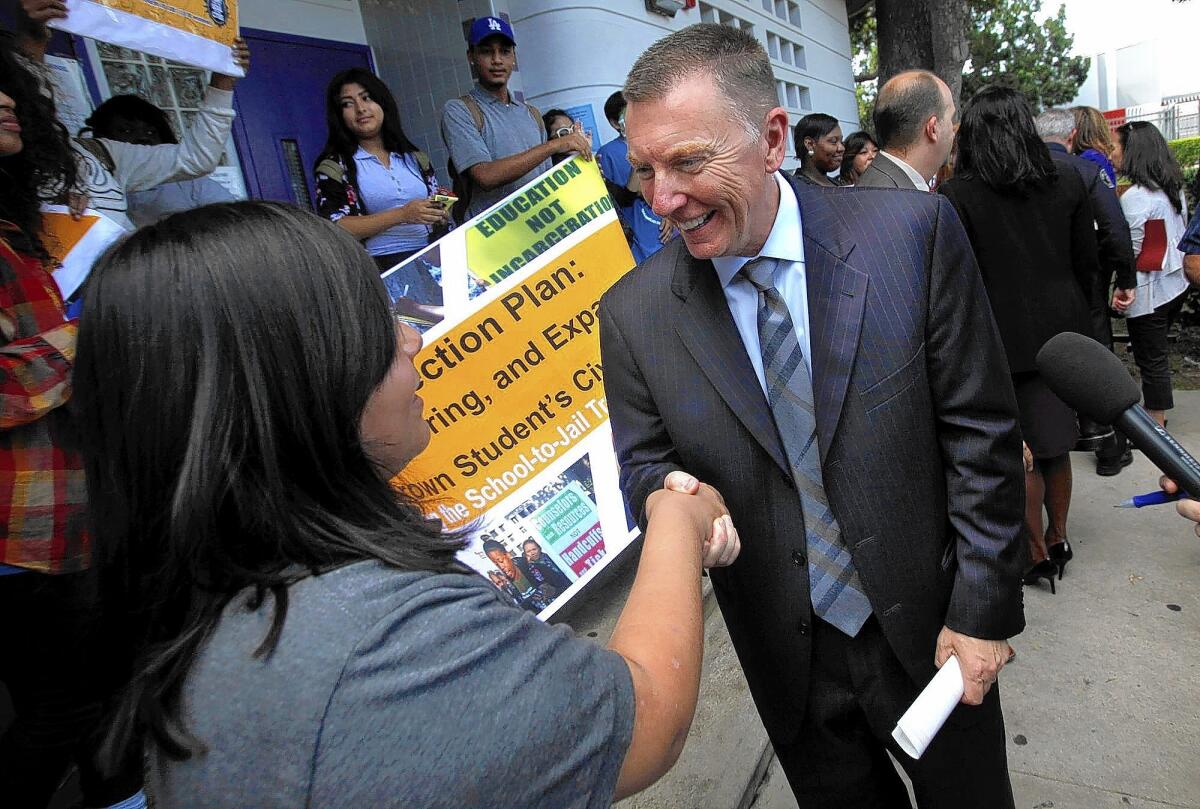 LAUSD Supt. John Deasy shakes hands with Manual Arts High School seniorLaura Aguilar, 17 after the district announced a new program in which school police will no longer issue citations for minor offenses.