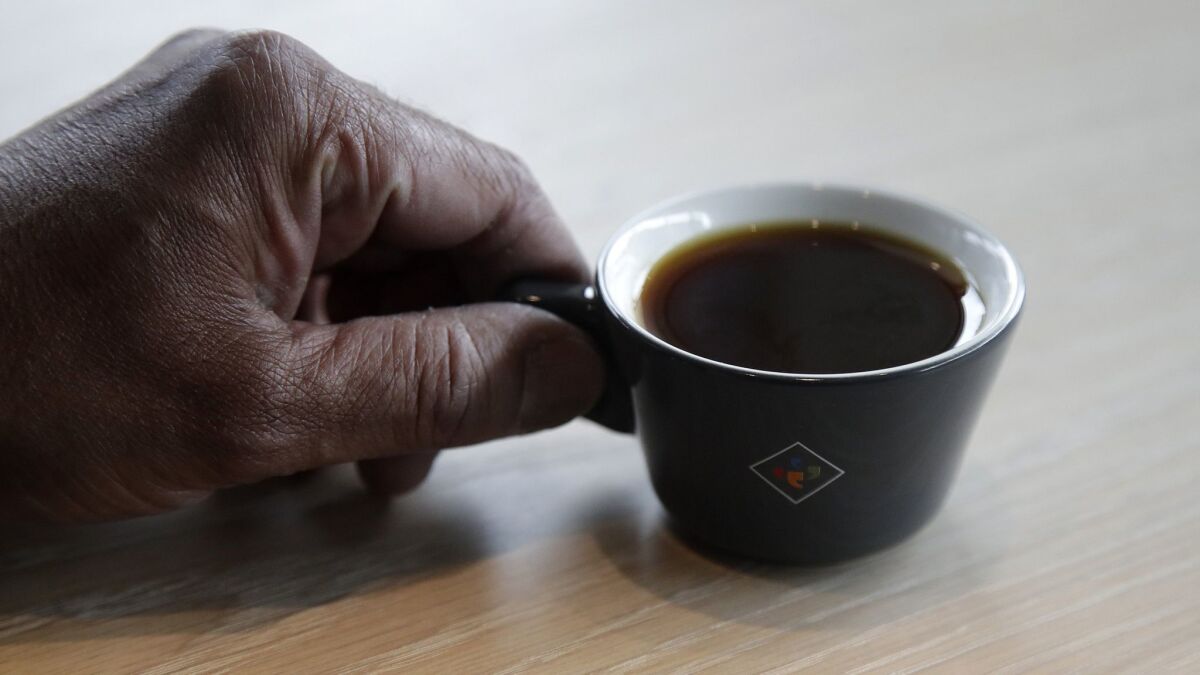 Klatch Coffee owner Bo Thiara holds a cup of Elida Natural Geisha 803 coffee at his shop in San Francisco on May 15.