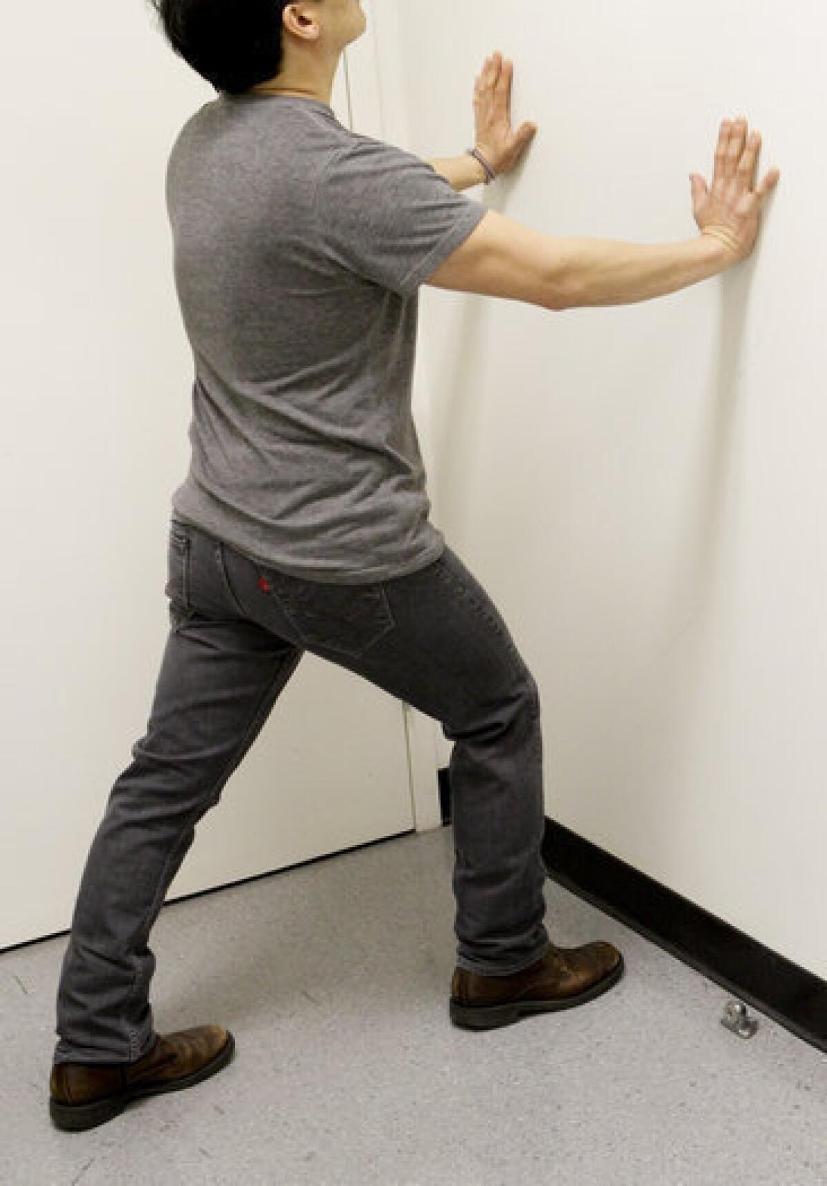 Help relieve heel pain with a calf stretch that involves keeping both heels on the ground while pushing against a wall.