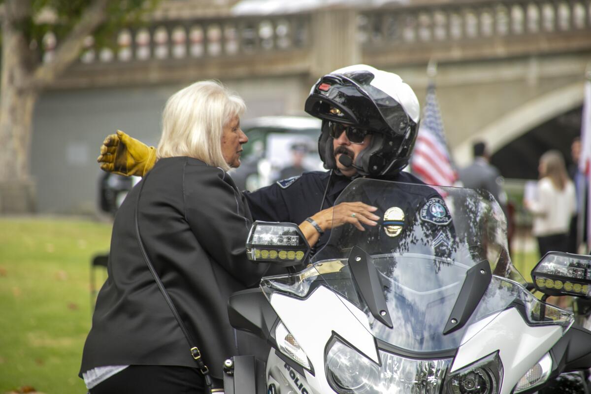 Luciana Coutchie, the late Jon Coutchie's mother, gets a hug from motorcycle Cpl. Bill Hume.