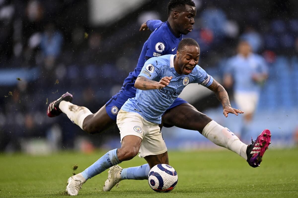 Kurt Zouma, de Chelsea, atrás, y Raheem Sterling del Manchester City 