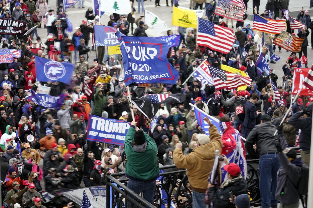 A large group of people, many with U.S. and Trump flags