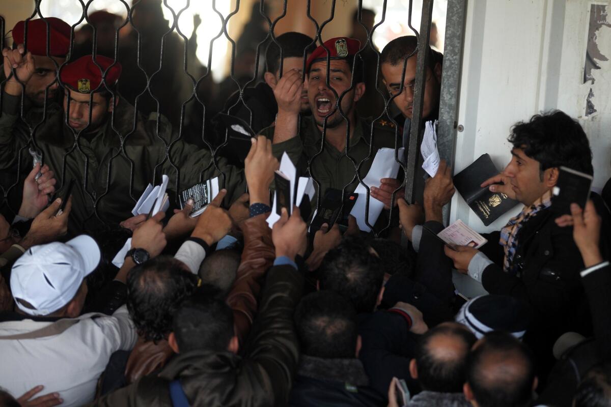 Palestinians await permission to enter Egypt as they gather inside the Rafah border crossing between Egypt and southern Gaza Strip on Sunday.