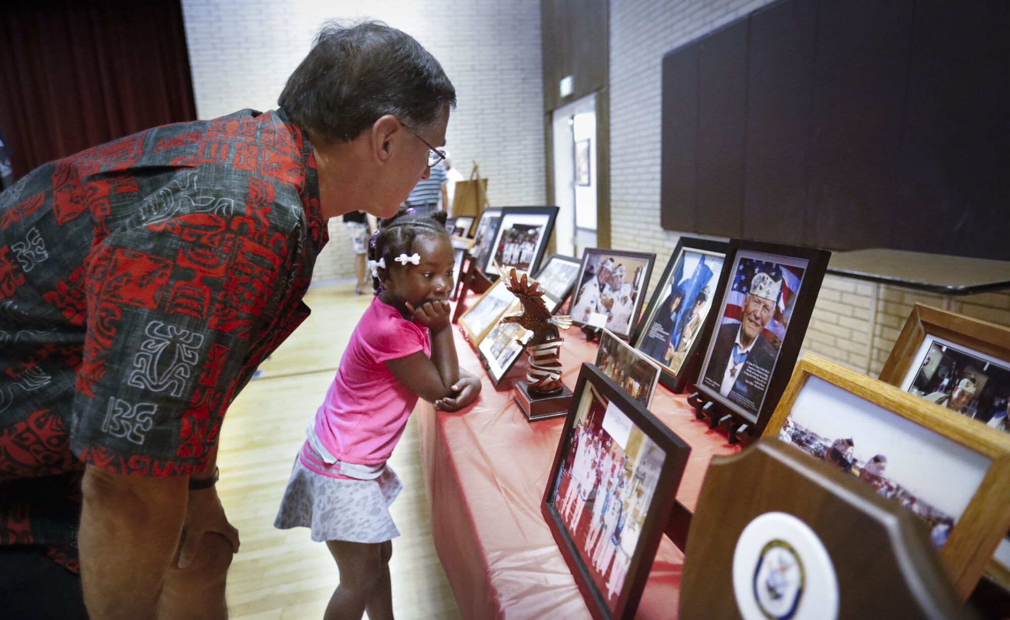 David Ybarra, left, and his 6-year-old daughter, Mia Rose Ybarra, look at Pearl Harbor memorabilia