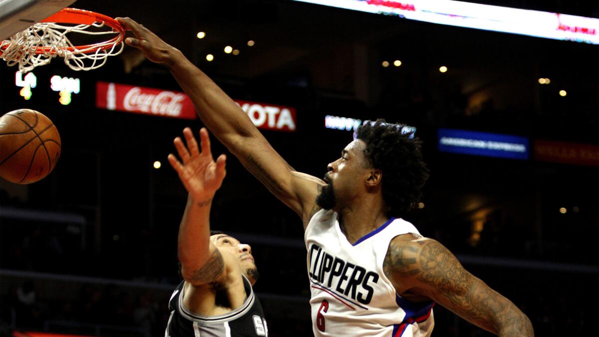 Clippers center DeAndre Jordan tries to dunk over Spurs guard Danny Green, but the ball caught the rim and spun out late in the game.
