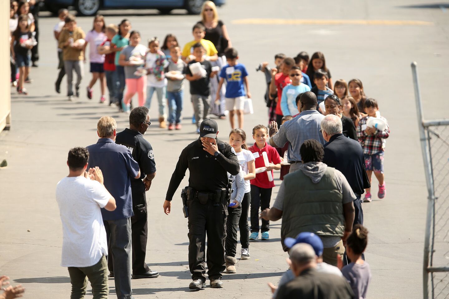Children walk in single file to be reunited with parents at Cajon High School after a school shooting at North Park Elementary School in San Bernardino.