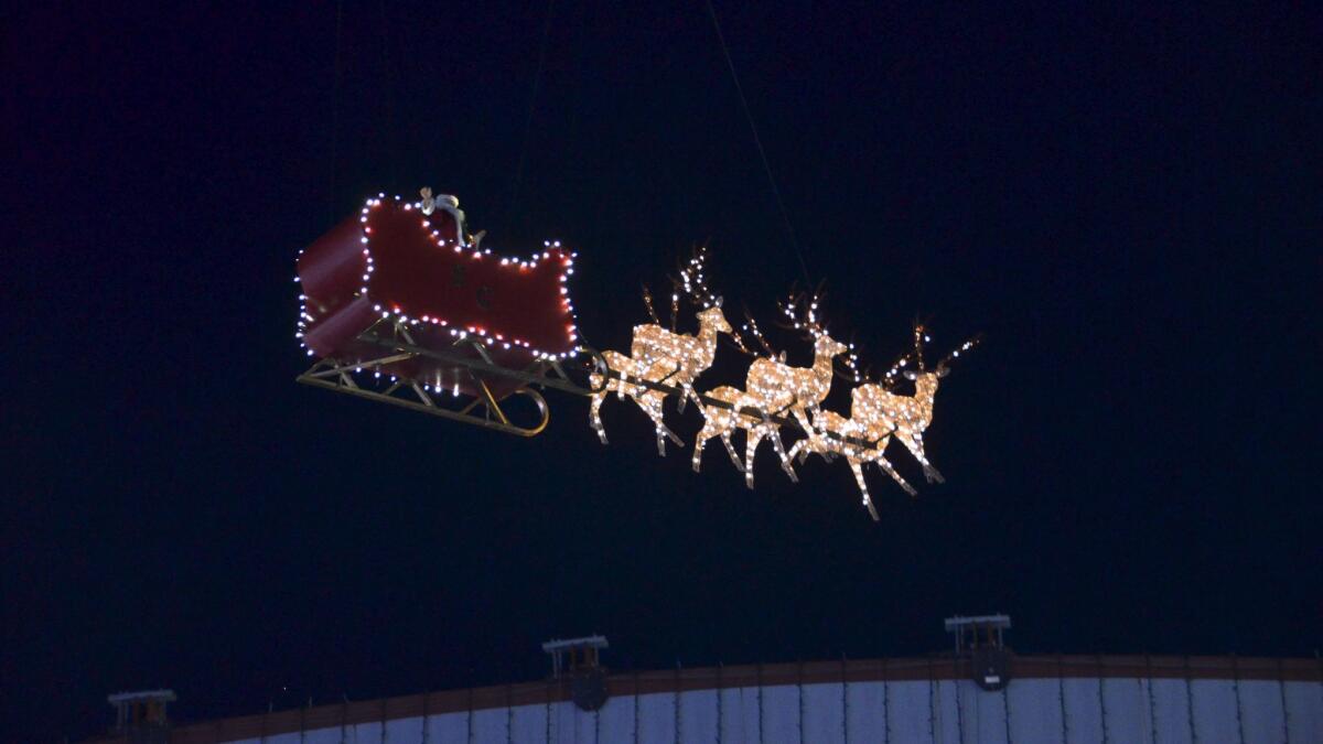 Santa and his reindeer fly across the sky in his sled during Winter Fest at the OC Fair & Event Center in 2016.
