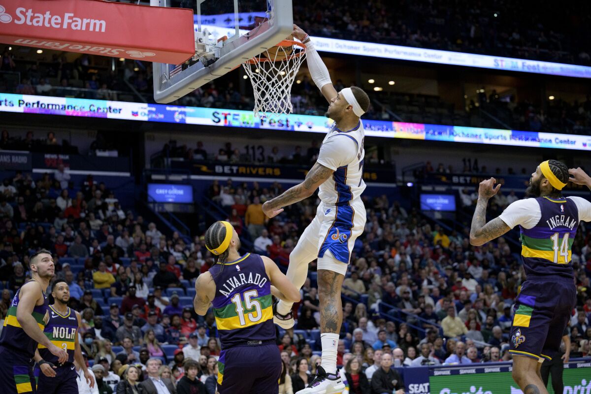Washington Wizards center Daniel Gafford (21) dunks against New Orleans Pelicans guard Jose Alvarado (15) in the first half of an NBA basketball game in New Orleans, Saturday, Jan. 28, 2023. (AP Photo/Matthew Hinton)