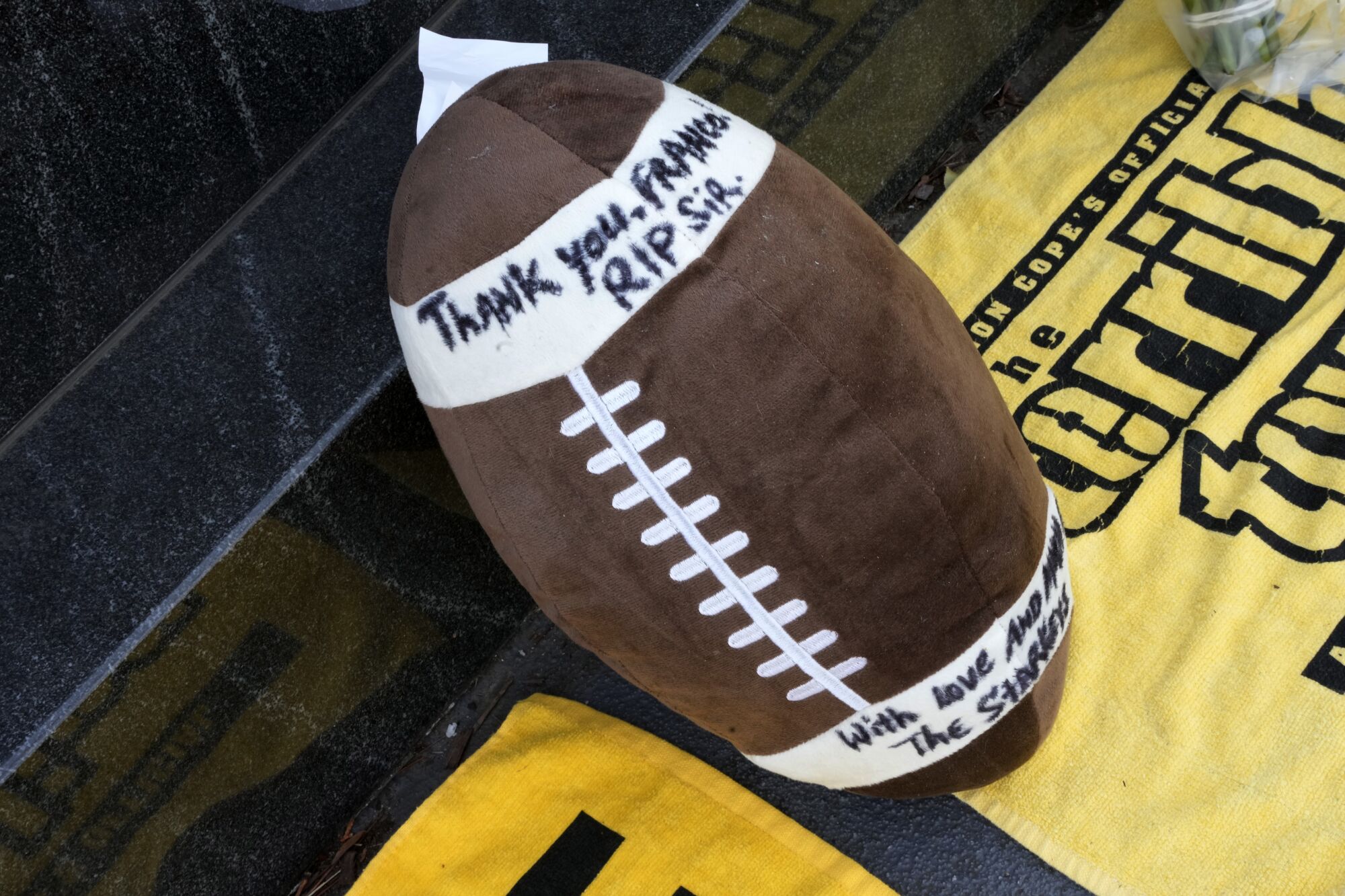 A stuffed football is placed at the Immaculate Reception memorial outside Acrisure Stadium in Pittsburgh 