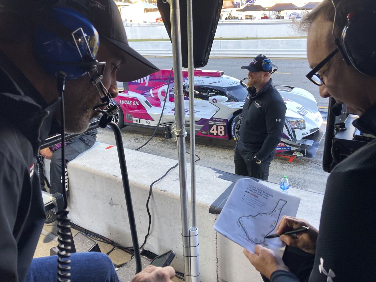 Jimmie Johnson, left, listens to crew chief Chad Knaus, Friday, Nov. 12, 2021, at Road Atlanta Raceway in Braselton, Georgia. Johnson and Knaus won a record-tying seven NASCAR championships together before their relationship fractured and they split in 2019 after 17 seasons together. The two have been reunited by work four times this season as Knaus has run a sports car team that Johnson and Hendrick Motorsports put together in partnership with Action Express in four IMSA endurance sports car races this year. Both say their relationship is currently in a good place. (AP Photo/Jenna Fryer)