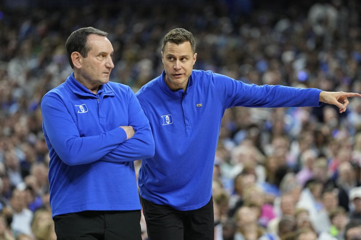 Duke assistant coach Jon Scheyer and head coach Mike Krzyzewski work during the first half of a college basketball game in the semifinal round of the Men's Final Four NCAA tournament, Saturday, April 2, 2022, in New Orleans. (AP Photo/David J. Phillip)