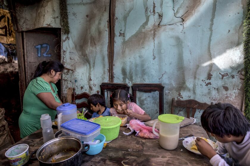 Consuelo Pascacio's three children; Estiben 4, Estefany, 11, and Javier, 14, dig into a chicken rice stew she picked up at a "community pot," in their home in the Nueva Esperanza neighborhood of Lima, Peru, Monday, June 8, 2020. For many residents the "community pot" is their only defense against a hunger that's become a constant feature of life amid the new coronavirus pandemic. (AP Photo/Rodrigo Abd)
