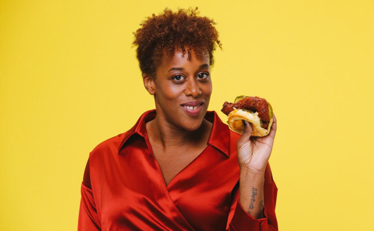 A woman holds a chicken sandwich