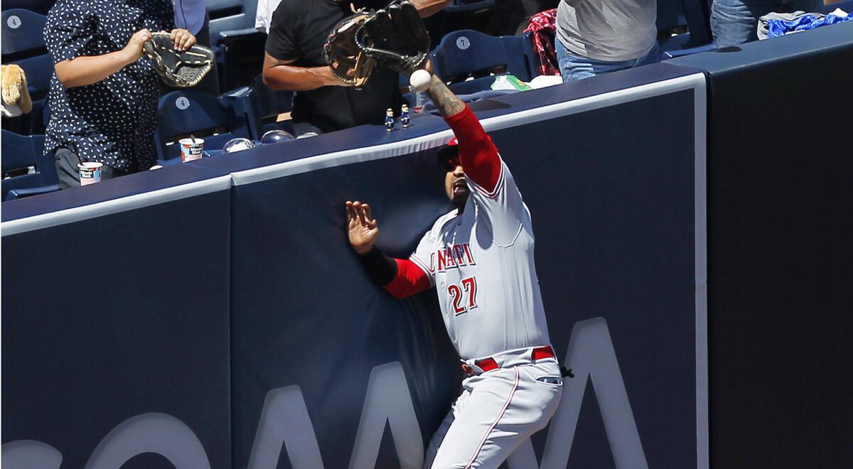 Reds outfielder Matt Kemp crashes into the wall trying to catch a fly ball by San Diego's Wil Myers on April 21.