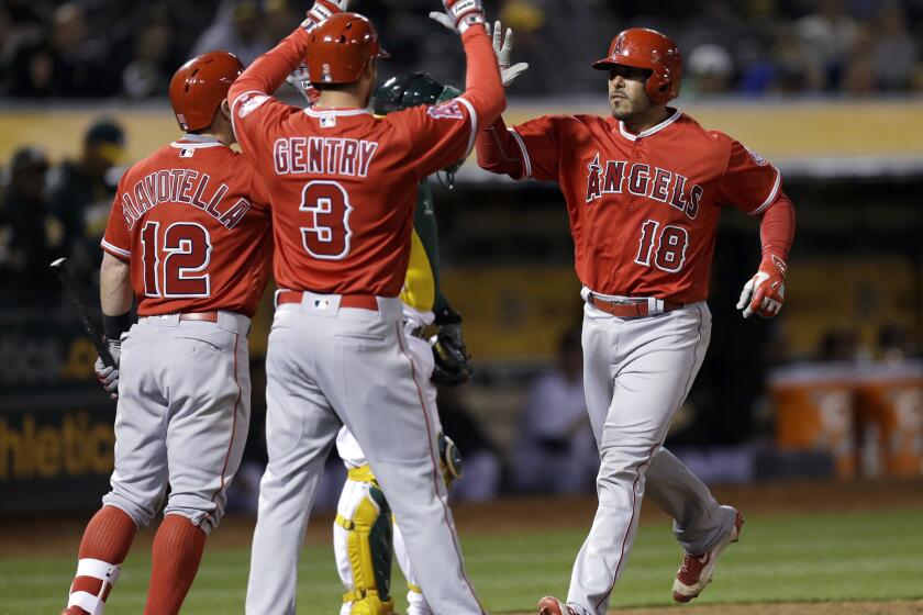 Geovany Soto is congratulated by Johnny Giavotella (12) and Craig Gentry (3) after hitting a two-run home run in the ninth inning of the Angels' 5-4 win over the Athletics on April 12.