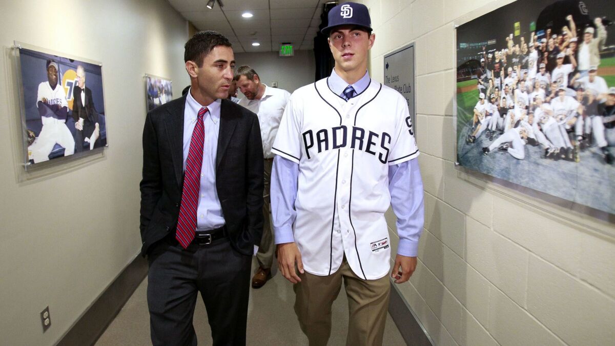 Padres first-round selection left handed pitcher MacKenzie Gore, right, walks with Padres General Manager A.J. Preller through a hallway as they make their way to the field at Petco Park in San Diego on Saturday, June 24, 2017.