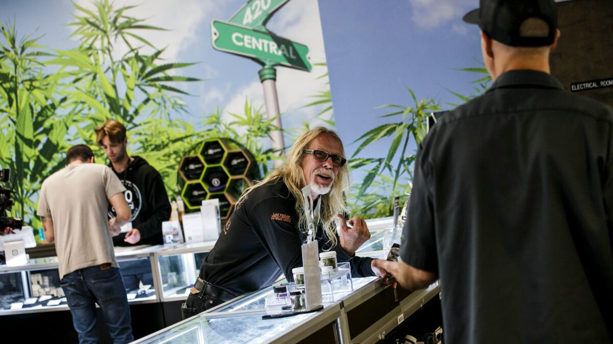 Customer Kurt Elvis, center, talks to 420 Central employee Kevin Gardner, right, on the first day of legal recreational pot sales in California.