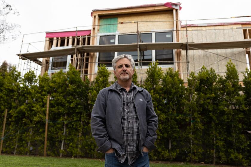 Eric Rosenzweig poses in the backyard of his College East home where construction of 7 ADUs can be seen on Friday, April 14, 2023. In an effort to maintain privacy, Rosenzweig spent thousands to plant trees.