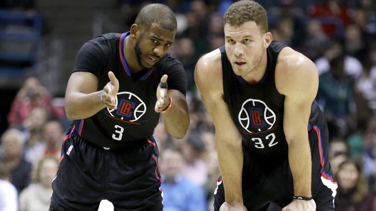 Clippers point guard Chris Paul (3) talks to forward Blake Griffin during a break in play against the Bucks on Friday night.