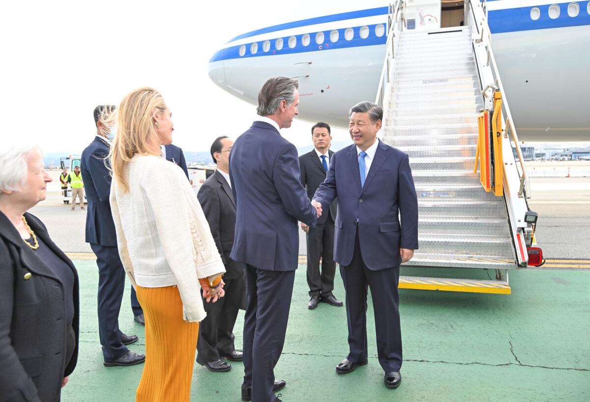 Xi Jinping and Gov. Gavin Newsom shake hands on a tarmac.