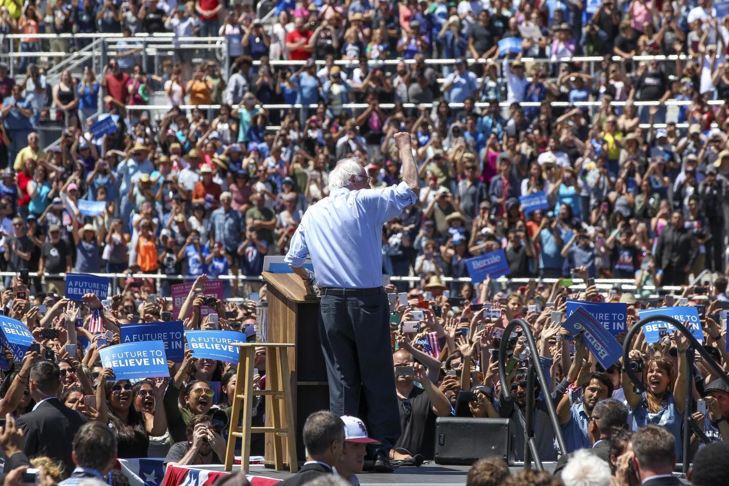 Democratic presidential candidate Bernie Sanders holds up a fist to a cheering crowd after walking up to the podium at Rancho Buena Vista High School in Vista.