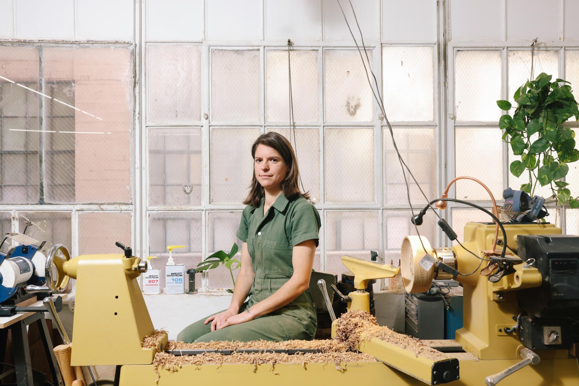 Julie Jackson sits on her lathe in her woodshop.