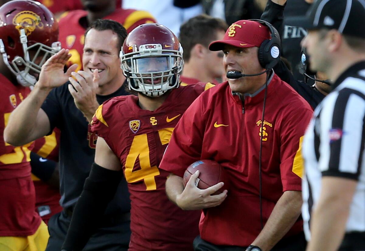 USC Coach Clay Helton reacts after being handed the ball following an interception by Trojans cornerback Iman Marshall in the fourth quarter against UCLA.