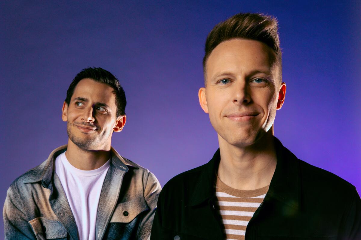 Benj Pasek looks to the side as Justin Paul looks at the camera for a portrait.