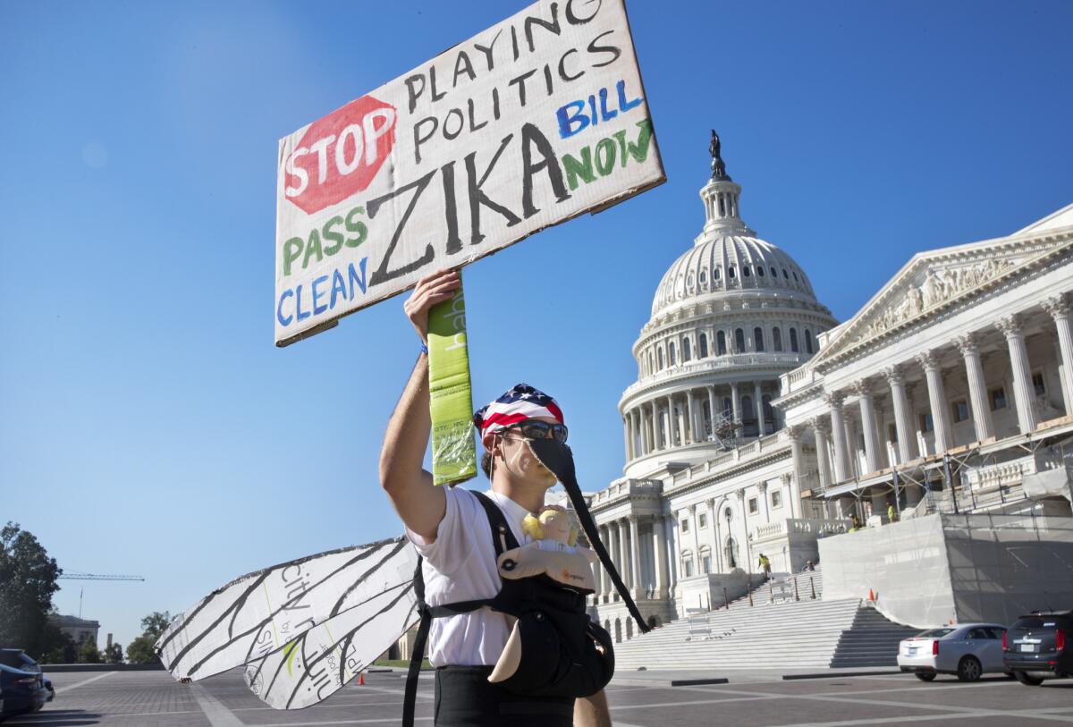 Wearing a homemade mosquito costume, an expectant father protests this month, calling on Congress to pass a bill that includes funding to combat the Zika virus. Congress approved a deal Wednesday night.