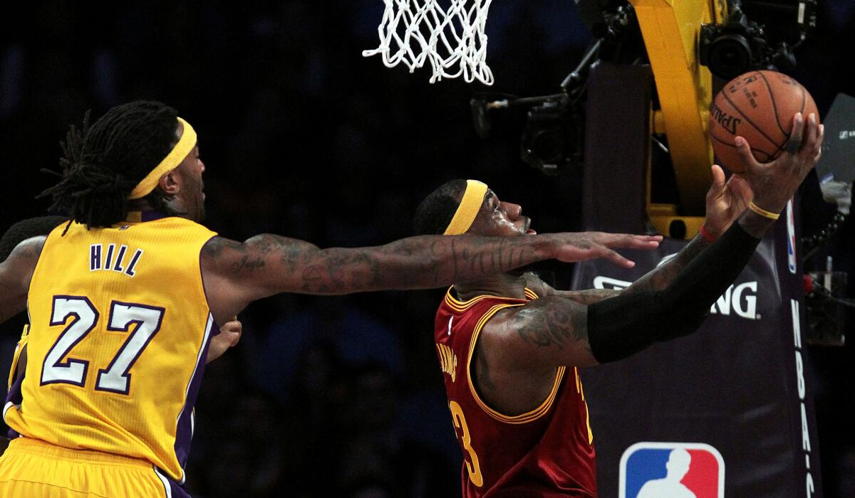 Cavaliers forward LeBron James attempts a reverse layup against Lakers center Jordan Hill in the first half Thursday night at Staples Center.