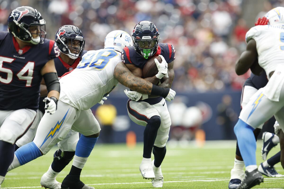 Texans running back Dameon Pierce (32) is tackled by the Chargers' Tre' McKitty.