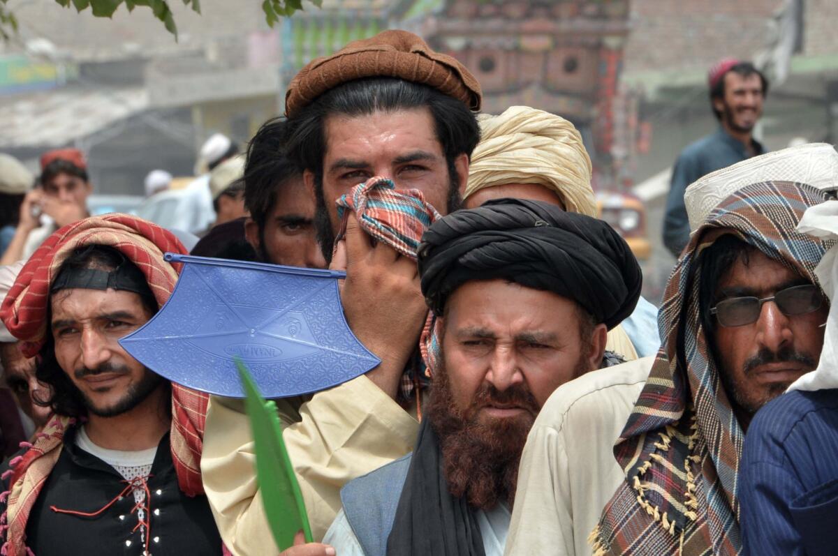 Internally displaced Pakistani civilians fleeing a military operation against Taliban militants in the North Waziristan tribal agency line up outside the World Food Program food distribution center in Bannu on Sunday.