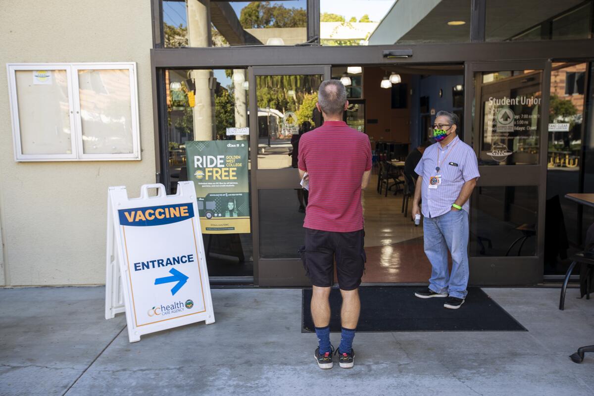 A man waits in line at a clinic at Golden West College for a COVID-19 vaccine on Wednesday.