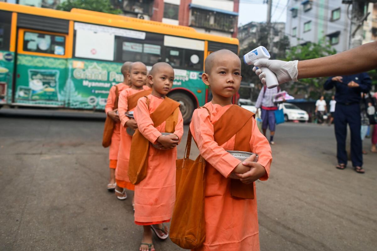 Young Buddhist nuns line up to have their temperature taken by authorities in Yangon, Myanmar.