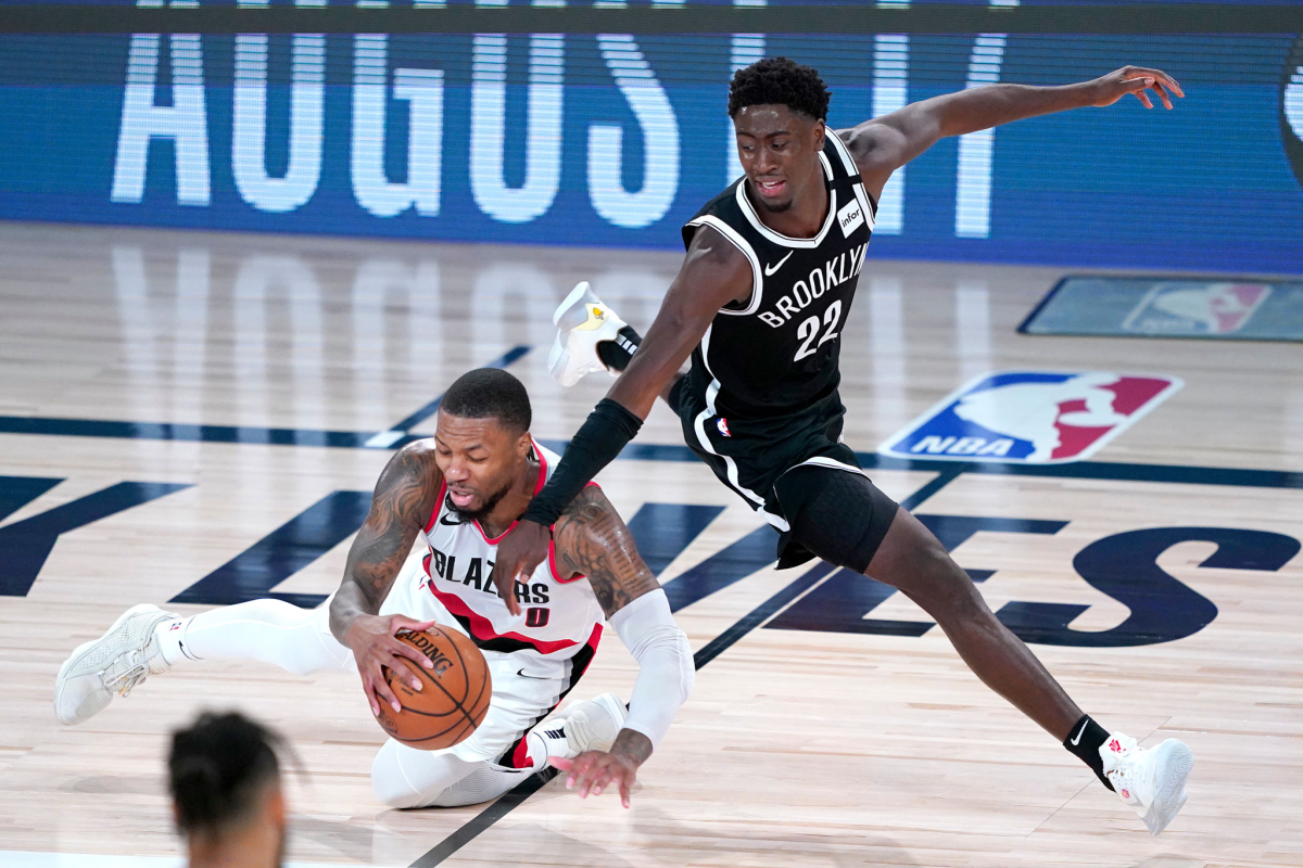 Portland's Damian Lillard chases the ball in front of Brooklyn's Caris LeVert on Thursday in Lake Buena Vista, Fla.
