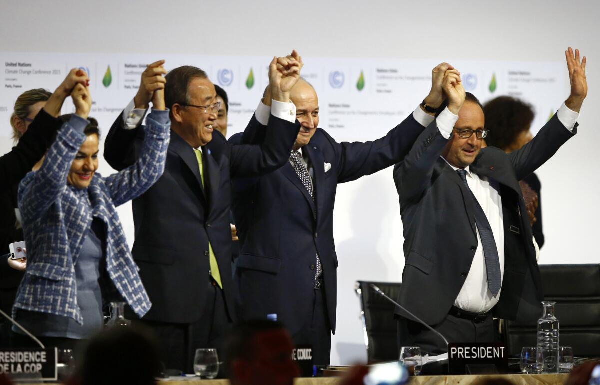 United Nations climate chief Christiana Figueres, left; U.N. Secretary-General Ban Ki-moon; French Foreign Minister Laurent Fabius, president of the climate change conference; and French President Francois Hollande celebrate at the end of the meeting.