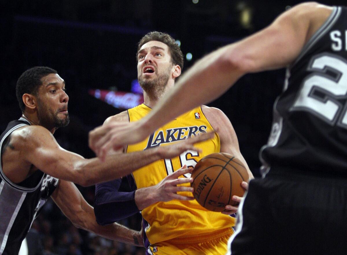 Lakers power forward Pau Gasol drives to the basket against Spurs big men Tim Duncan, left, and Tiago Splitter in the second half.