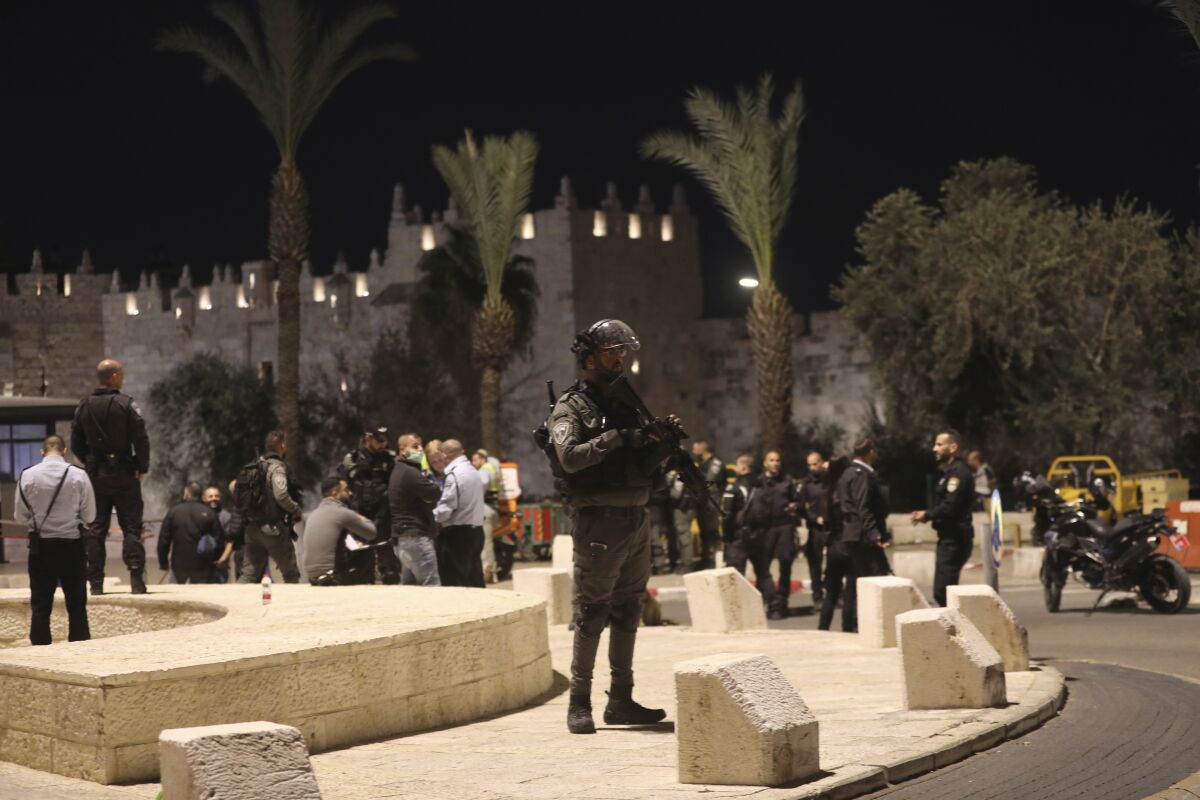 An Israeli policeman stands guard near Damascus Gate to the Old City of Jerusalem, Saturday, Dec. 4, 2021. Israeli police shot a Palestinian on Saturday after an ultra-Orthodox Jewish man was stabbed and wounded near Damascus Gate in Jerusalem's Old City, a crowded area that is often the scene of demonstrations and clashes.(AP Photo/Mahmoud Illean)