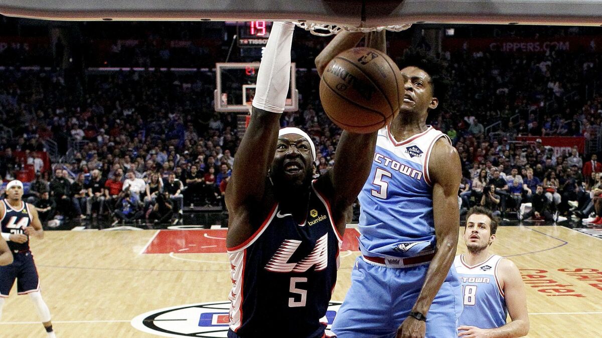 Clippers center Montrezl Harrell dunks against the Kings during the second half Sunday.