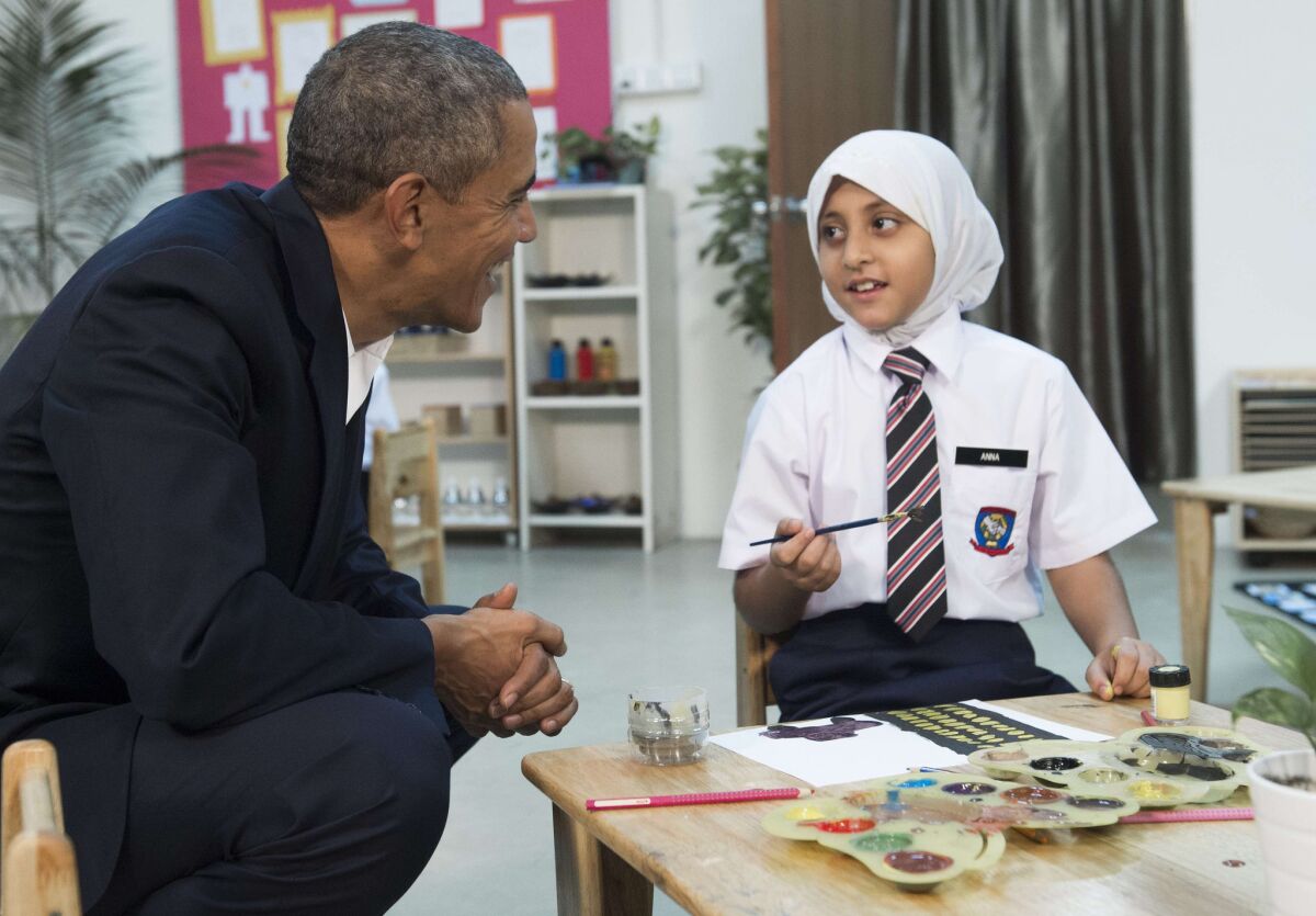 President Obama speaks with a young girl as he tours the Dignity for Children Foundation in Kuala Lumpur, Malaysia, on Saturday. The girl was rescued from traffickers after being separated from her family as they fled Myanmar and will be resettled in the United States.
