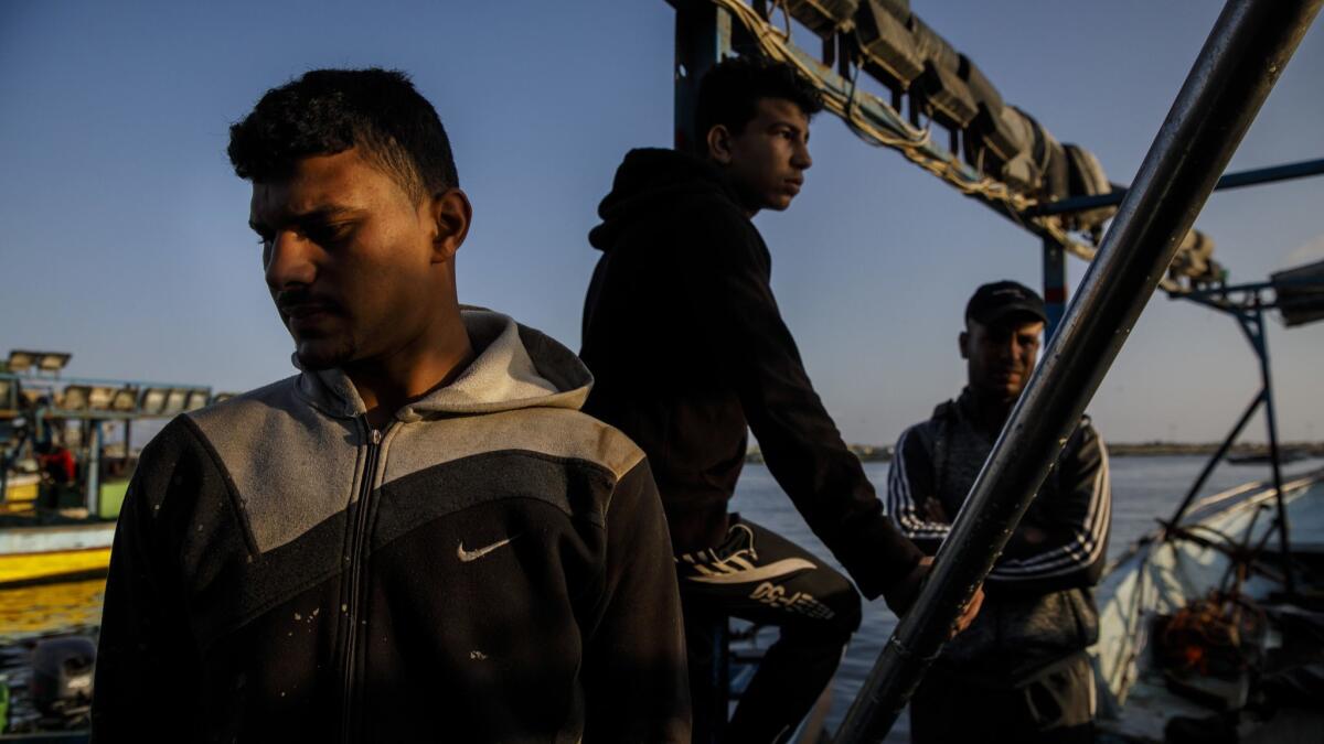 Mahmud Abu Riyala, cousin of the Ismail Abu Riyala, 18, who was killed by Israeli forces while sailing off the Gaza coast, fixes his boat that was damaged during the shooting.