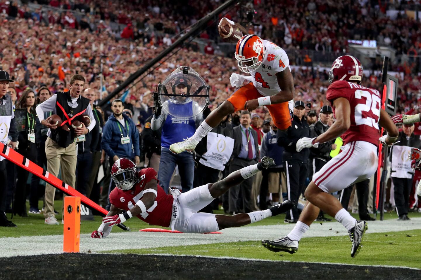Clemson quarterback Deshaun Watson leaps over Alabama defensive back Ronnie Harrison to get to the one-yard line during the fourth quarter.