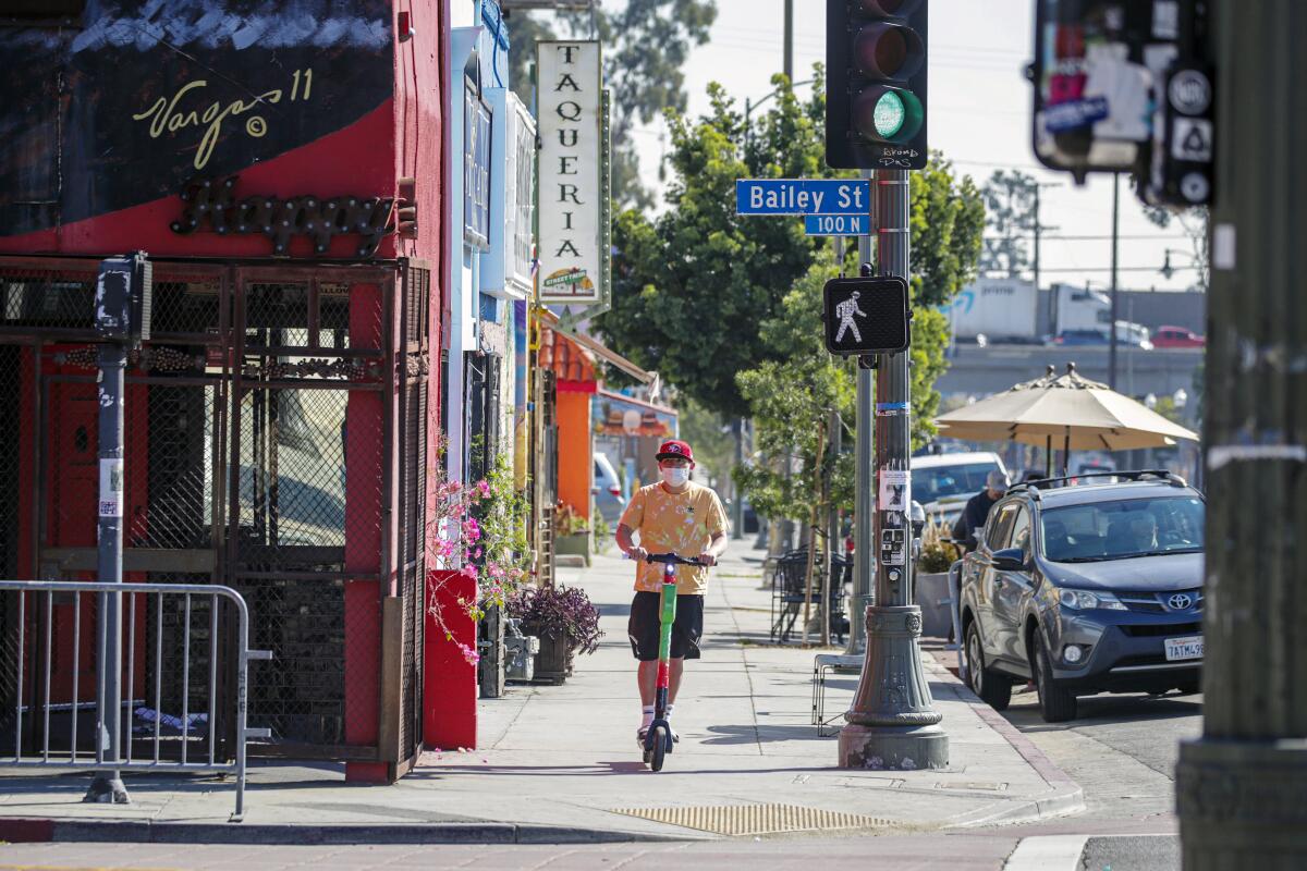 A person rides a scooter down Bailey Street