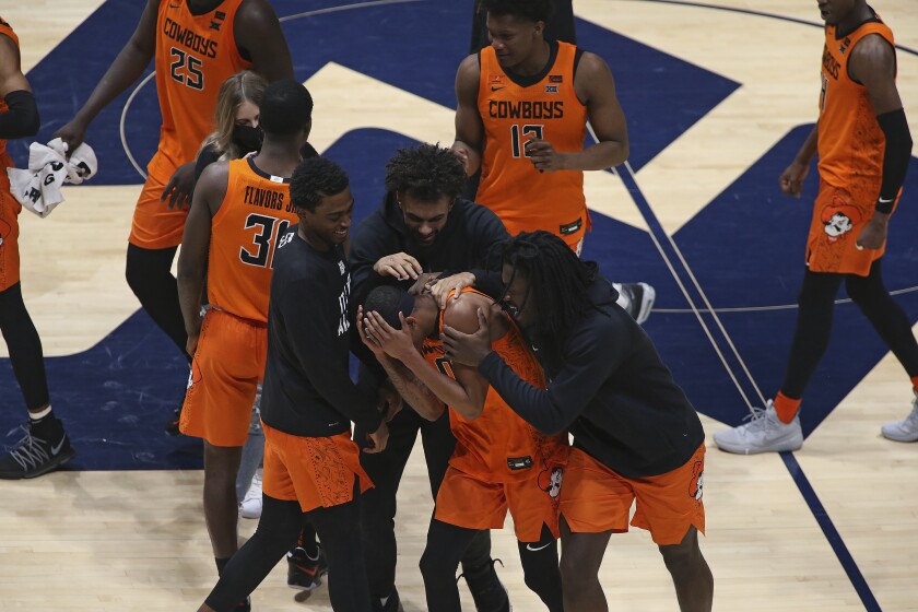 Oklahoma State guard Avery Anderson III, center, celebrates after defeating West Virginia in an NCAA college basketball game Saturday, March 6, 2021, in Morgantown, W.Va. (AP Photo/Kathleen Batten)