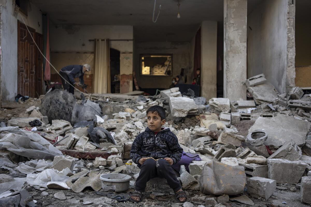 A Palestinian boy sits on the rubble of a destroyed building after an Israeli strike in Rafah, southern Gaza Strip.