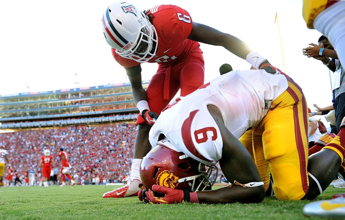 Trojans receiver Marqise Lee (9) is consoled by Wildcats cornerback Jonathan McKnight after a Hail Mary pass by USC fell incomplete to give the victory to Arizona, 39-36, on Saturday.